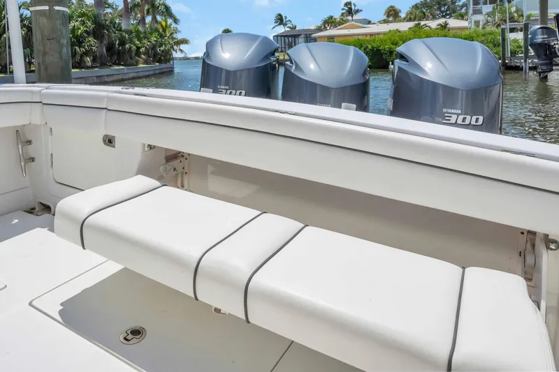 Slide: The Image of 2017 Jupiter 34 FS boat with triple Yamaha 300 engines, docked near lush greenery. - 19