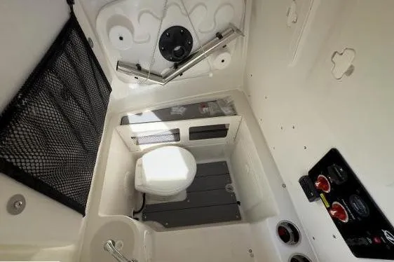Slide: The Image of 2024 Sailfish 242 CC boat interior with compact marine toilet and storage features. - 12