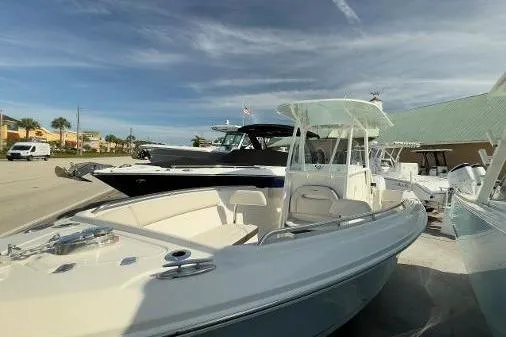 Slide: The Image of 2024 Sailfish 242 CC boat displayed outdoors under a partly cloudy sky. - 15