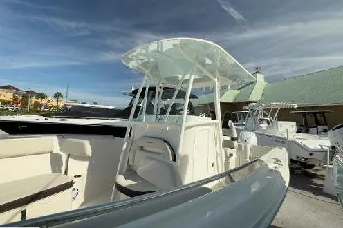 Slide: The Image of 2024 Sailfish 242 CC boat with sleek design and spacious deck in marina setting. - 16