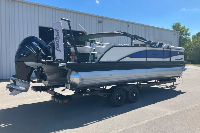 Slide: The Image of 2023 Barletta CORSA 25UE pontoon boat with Mercury engine on trailer. - 2