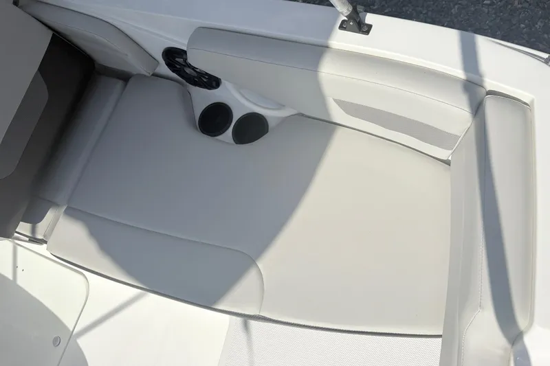 Slide: The Image of 2024 Hurricane SS boat interior with white cushioned seating and cup holders. - 13