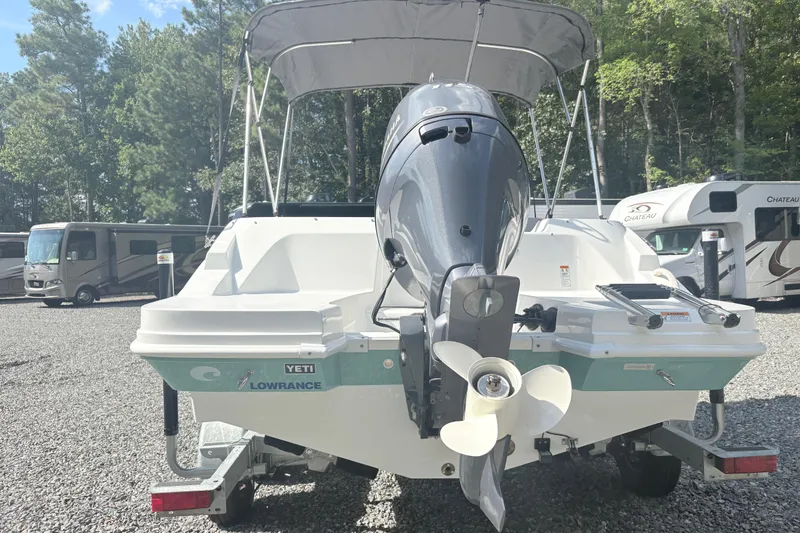 Slide: The Image of 2024 Hurricane SS boat with motor, parked near RVs in a wooded area. - 3