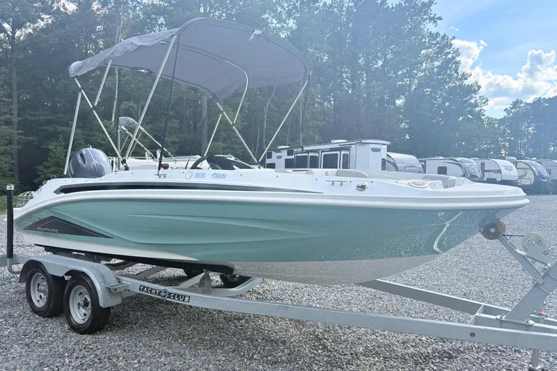 Slide: The Image of 2024 Hurricane SS boat on trailer, parked outdoors with canopy and motor. - 5