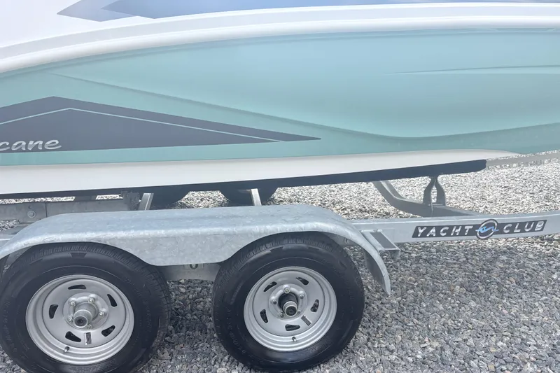 Slide: The Image of 2024 Hurricane SS boat on Yacht Club trailer, parked on gravel. - 9