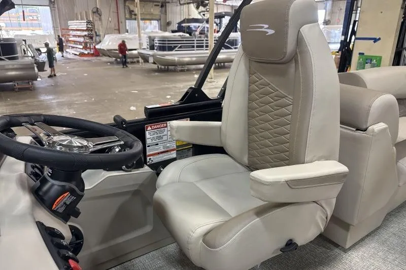 Slide: The Image of 2026 Bennington 22 SSRSE boat interior with beige captain's chair and steering wheel. - 23