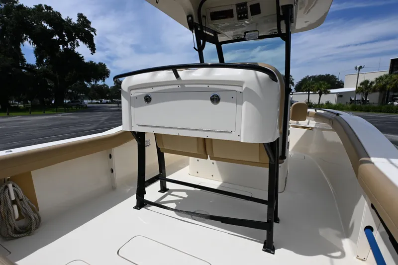 Slide: The Image of 2021 Scout 255 LXF boat interior with seating and storage, under a clear blue sky. - 10