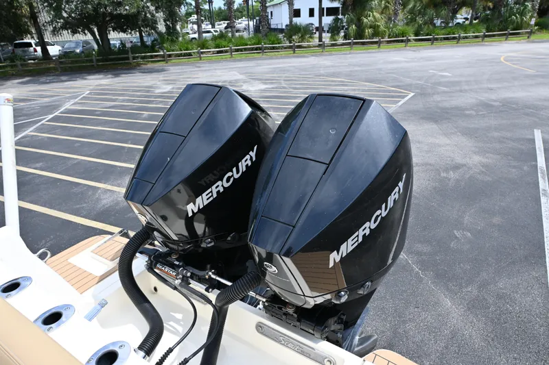 Slide: The Image of Twin Mercury outboard engines on a 2021 Scout 255 LXF boat in a parking lot. - 15