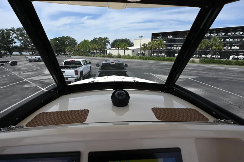 Slide: The Image of View from 2021 Scout 255 LXF boat dashboard, overlooking parking lot with trucks and trailers. - 6