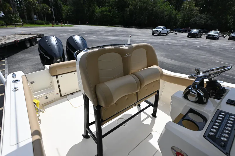 Slide: The Image of 2021 Scout 255 LXF boat interior with dual Mercury engines in parking lot. - 8
