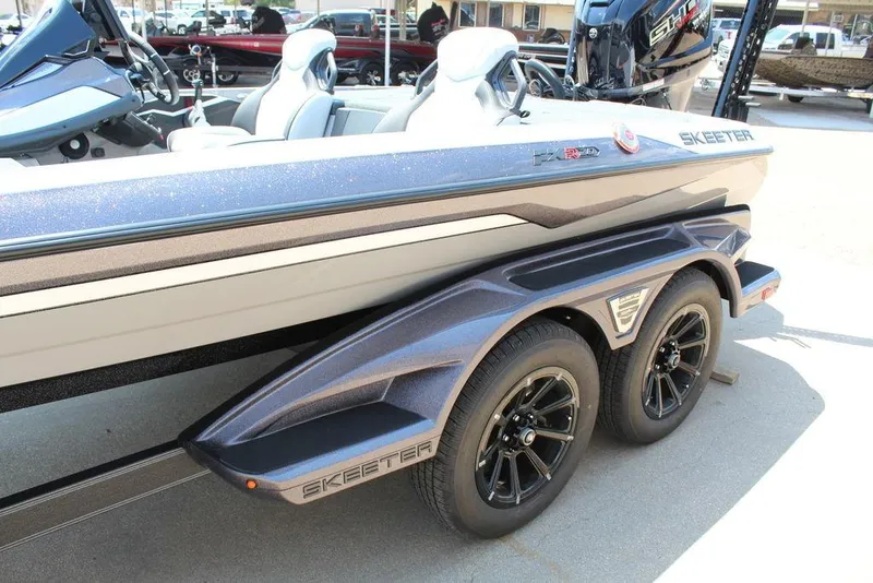 Slide: The Image of 2026 Skeeter FXR20 FLEX boat on trailer, showcasing sleek design and dual wheels. - 13
