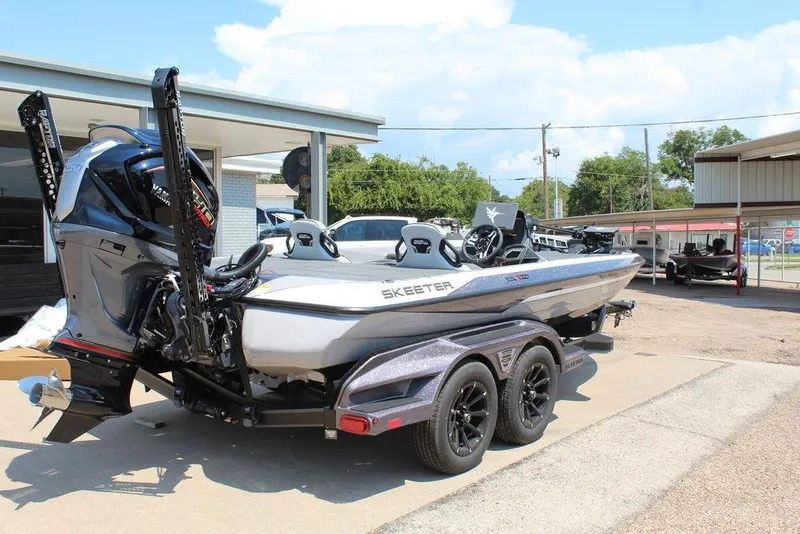 Slide: The Image of 2026 Skeeter FXR20 FLEX boat on trailer, parked outdoors under clear sky. - 6