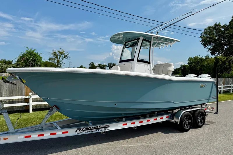 Slide: The Image of 2026 Sea Hunt Gamefish 25 boat on trailer, parked outdoors under clear sky. - 1