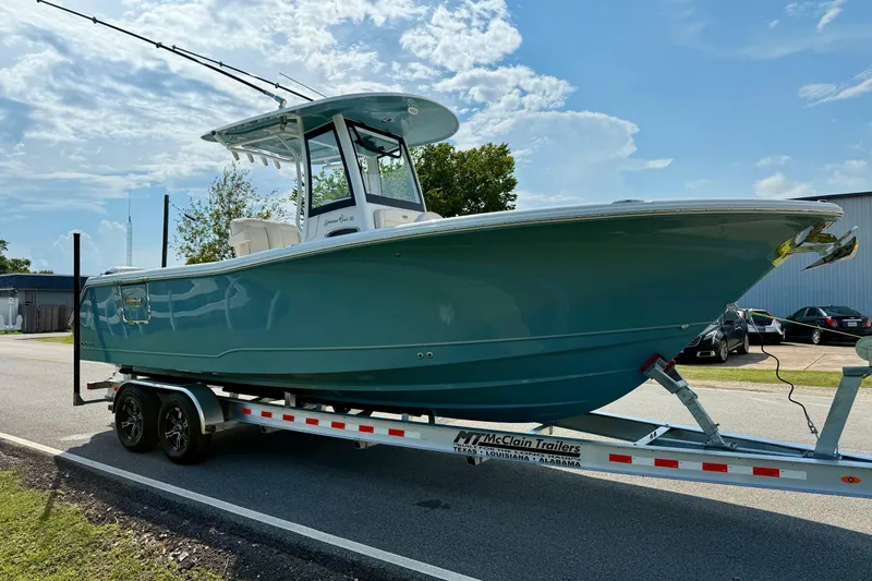 Slide: The Image of 2026 Sea Hunt Gamefish 25 boat on trailer, parked outdoors under a blue sky. - 5