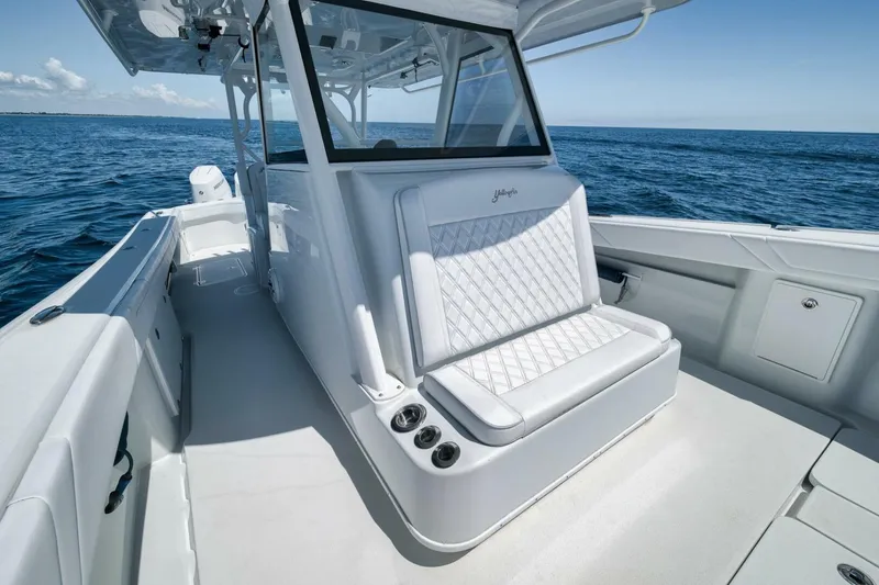 Slide: The Image of 2023 Yellowfin 39 Offshore boat interior with white seating, on open ocean. - 11