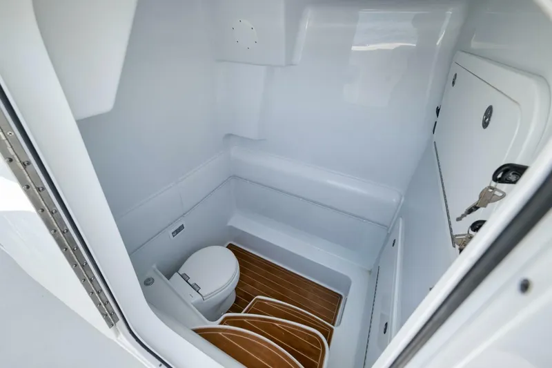 Slide: The Image of 2023 Yellowfin 39 Offshore boat interior with compact bathroom and wooden flooring. - 13
