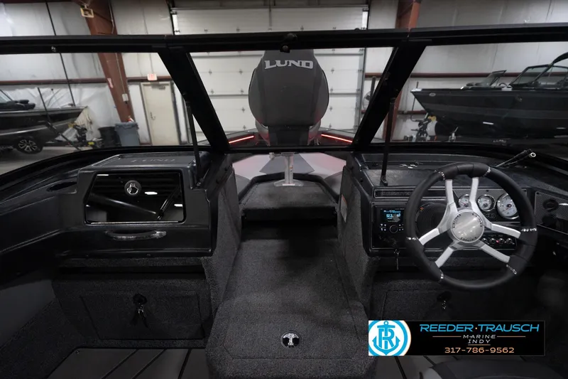 Slide: The Image of Interior view of 2026 Lund 1875 Crossover XS boat, featuring steering wheel and dashboard controls. - 16