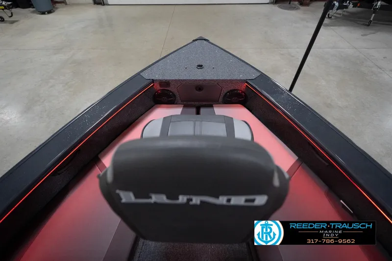 Slide: The Image of 2026 Lund 1875 Crossover XS boat interior with red LED lighting in a showroom. - 17