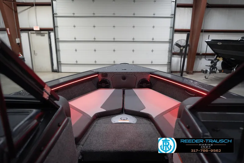 Slide: The Image of 2026 Lund 1875 Crossover XS boat interior with red LED lighting in a garage. - 31