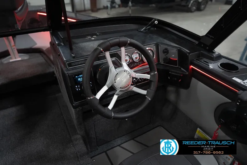 Slide: The Image of 2026 Lund 1875 Crossover XS boat interior with steering wheel and dashboard controls. - 34