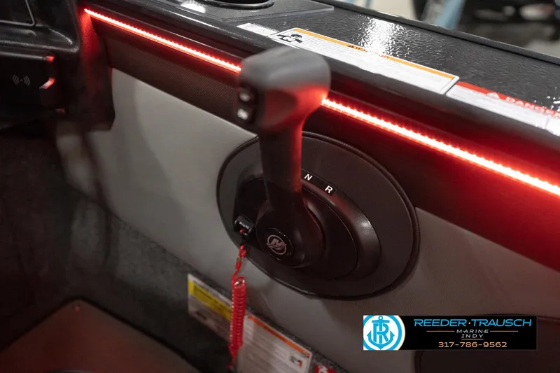 Slide: The Image of 2026 Lund 1875 Crossover XS boat interior with gear shift and red LED lighting. - 40