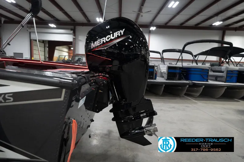Slide: The Image of 2026 Lund 1875 Crossover XS with Mercury outboard motor in showroom. - 49
