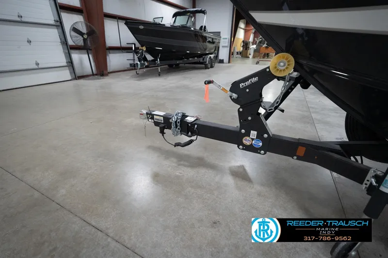 Slide: The Image of 2026 Lund 1875 Crossover XS boat in showroom with trailer hitch detail. - 56