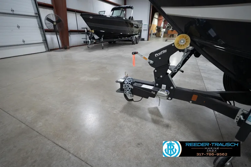 Slide: The Image of 2026 Lund 1875 Crossover XS boat in a showroom with trailer hitch detail. - 57