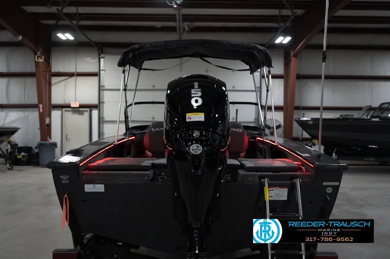 Slide: The Image of 2026 Lund 1875 Crossover XS boat with 150 HP engine in a showroom. - 9