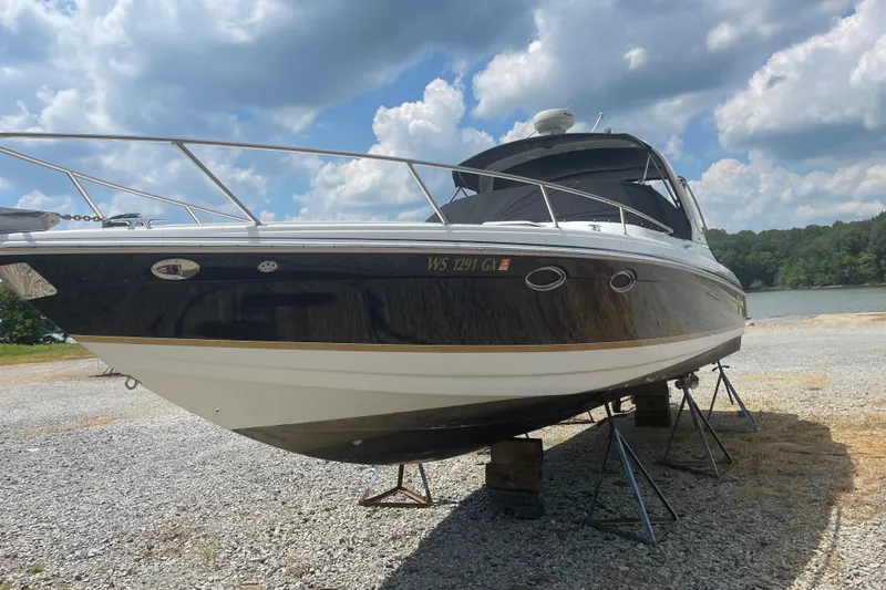 Slide: The Image of 2005 Formula 330 Sun Sport boat on stands, under a partly cloudy sky. - 0