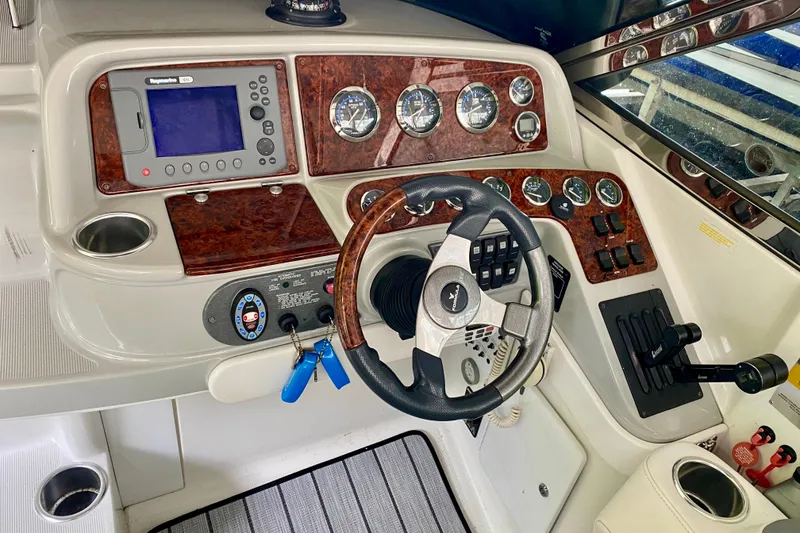 Slide: The Image of 2005 Formula 330 Sun Sport boat dashboard with steering wheel and navigation controls. - 12