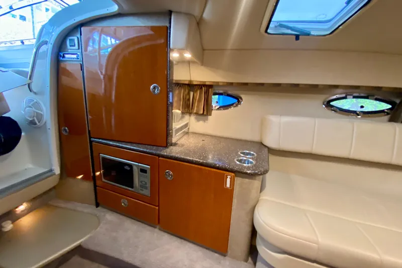 Slide: The Image of 2005 Formula 330 Sun Sport interior with kitchenette, microwave, and seating area. - 23
