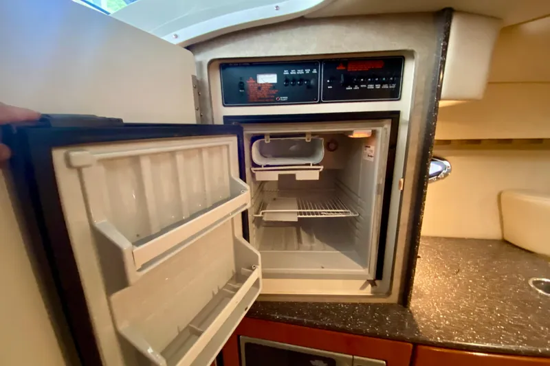 Slide: The Image of Open refrigerator inside 2005 Formula 330 Sun Sport boat cabin, showcasing interior storage space. - 25