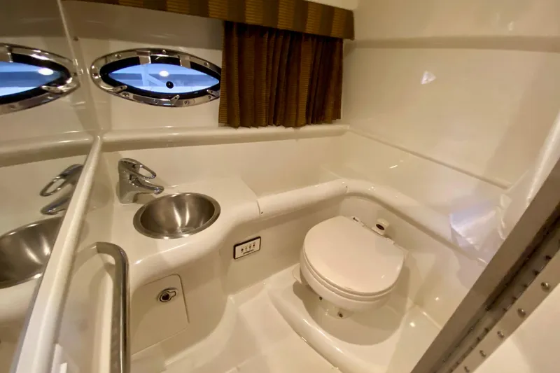 Slide: The Image of 2005 Formula 330 Sun Sport boat bathroom with sink, toilet, and porthole window. - 26