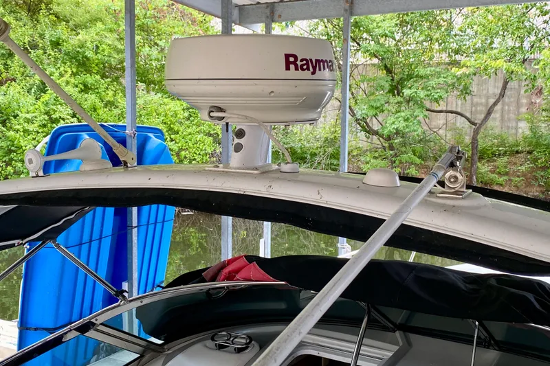 Slide: The Image of 2005 Formula 330 Sun Sport boat with Raymarine radar, docked near lush greenery. - 4