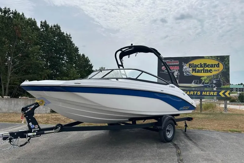 The Image of 2026 Yamaha AR195 boat on trailer, parked outdoors near BlackBeard Marine billboard. - 0