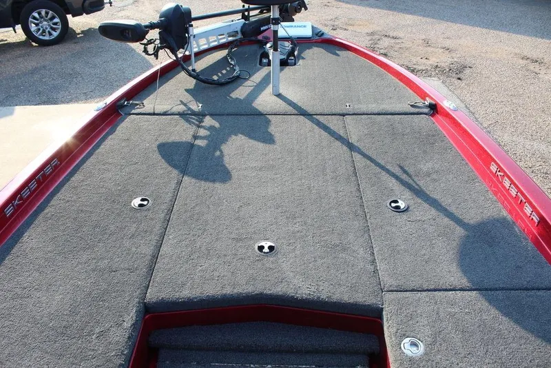 Slide: The Image of 2016 Skeeter ZX250 boat deck with trolling motor, red trim, and carpeted surface. - 10