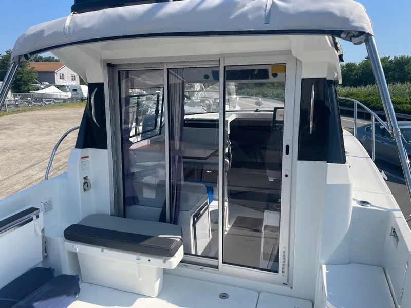 Slide: The Image of 2022 Jeanneau NC Weekender 795 Series 2 boat with sliding glass doors and seating area. - 11