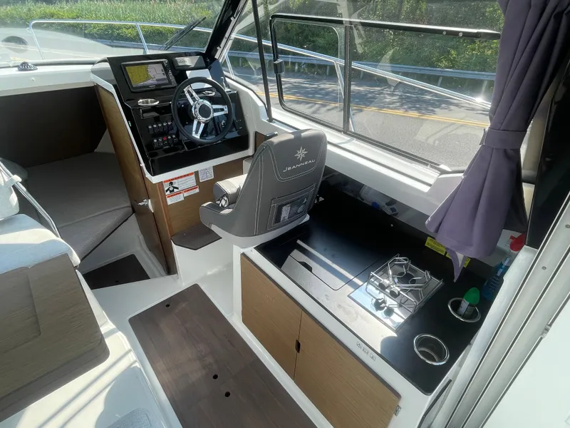 Slide: The Image of Interior of 2022 Jeanneau NC Weekender 795 Series 2, featuring helm and compact kitchen area. - 22