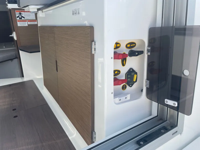Slide: The Image of 2022 Jeanneau NC Weekender 795 Series 2 interior with control panel and wooden cabinetry. - 26