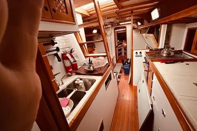 Slide: The Image of Interior of 1993 Brooklin Boat Yard Marshall 48, featuring a well-equipped kitchen area. - 15