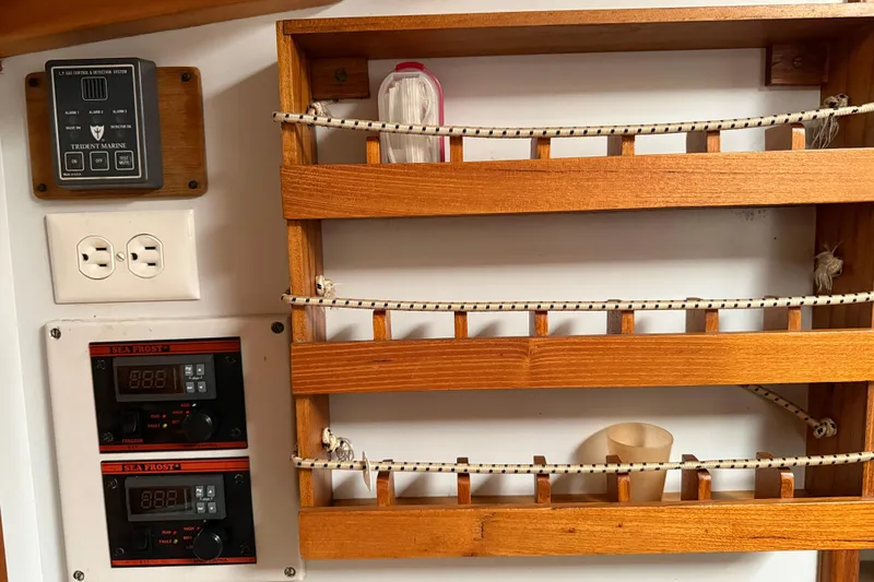 Slide: The Image of Wooden shelves and control panels inside a 1993 Brooklin Boat Yard Marshall 48. - 16