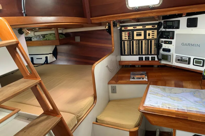 Slide: The Image of Interior of 1993 Brooklin Boat Yard Marshall 48, featuring navigation equipment and cozy sleeping area. - 19