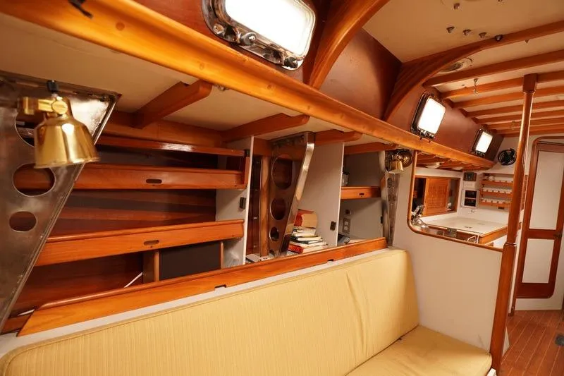 Slide: The Image of Interior of 1993 Brooklin Boat Yard Marshall 48, featuring wooden shelves and seating. - 30