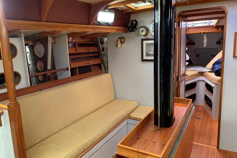 Slide: The Image of Interior of 1993 Brooklin Boat Yard Marshall 48, featuring wooden finishes and cozy seating. - 5