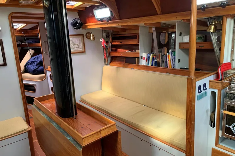 Slide: The Image of Interior of 1993 Brooklin Boat Yard Marshall 48, featuring cozy seating and wooden accents. - 6