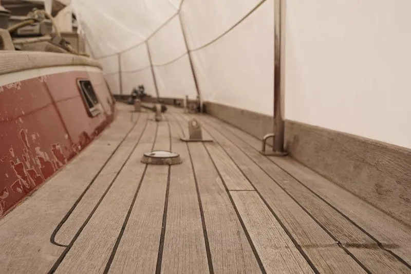 Slide: The Image of Wooden deck of a 1993 Brooklin Boat Yard Marshall 48 sailboat, showing weathered details. - 67
