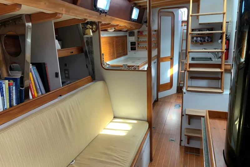 Slide: The Image of Interior of 1993 Brooklin Boat Yard Marshall 48, featuring cozy seating and wooden accents. - 8