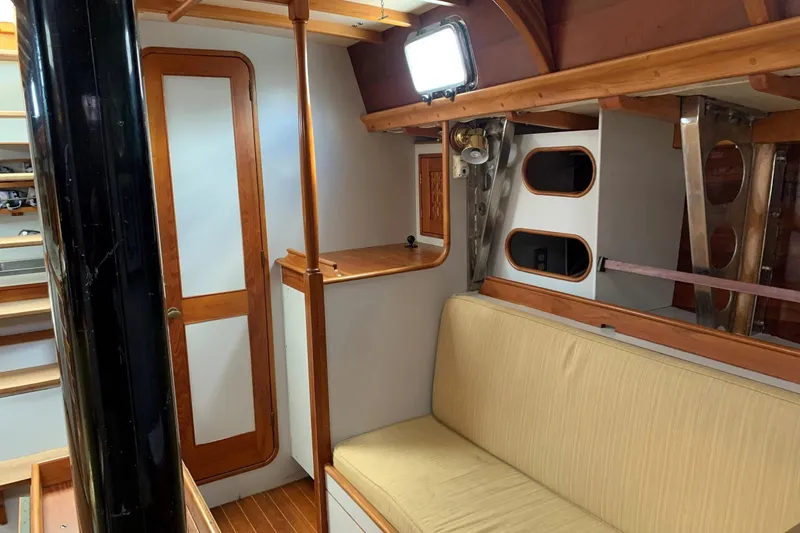 Slide: The Image of Interior of 1993 Brooklin Boat Yard Marshall 48, featuring wooden accents and cozy seating. - 9