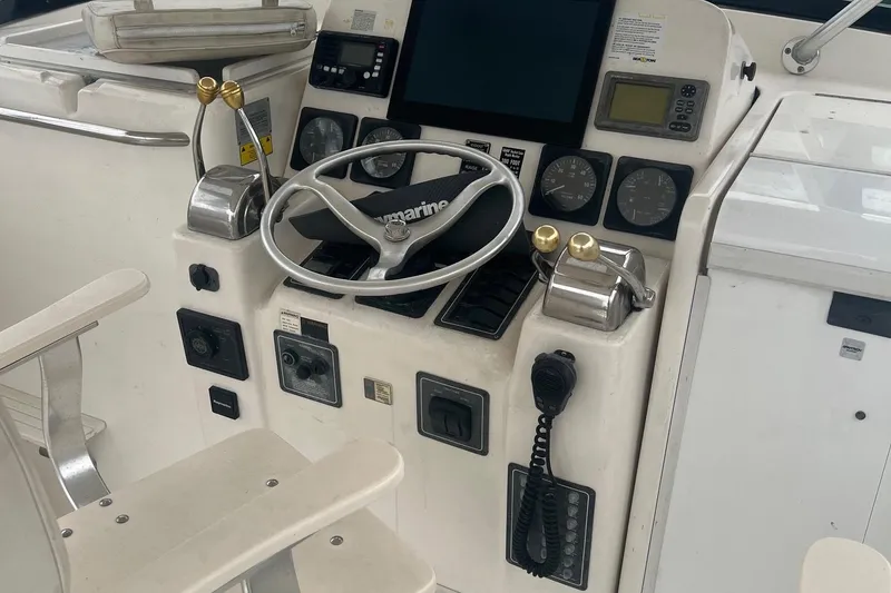 Slide: The Image of Control panel of a 2001 Pursuit 3000 Offshore boat with steering wheel and gauges. - 4